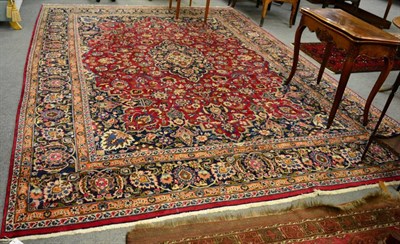 Lot 1281 - A Mashad carpet, North West Iran, the raspberry field of vines around an indigo medallion framed by