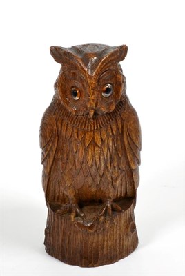 Lot 13 - A 1930's carved oak owl, tooled surface, glass eyes and a mouse between it's talons, 25.5cm