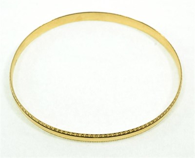 Lot 80 - A 9 carat gold bangle, with a decorative border, measures 7cm by 6.5cm inner diameter, 6mm wide