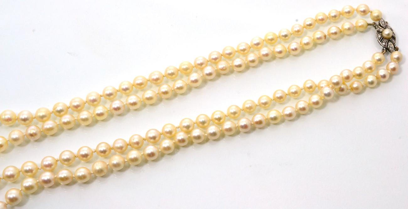 Lot 92 - A cultured pearl necklace, with a diamond and pearl set clasp, two strands of graduated...
