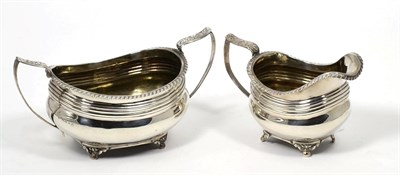 Lot 121 - A George III silver cream jug and twin handled sugar basin, Thomas Barker, London 1818, oval...