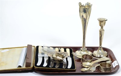 Lot 140 - A group of silver including a bud vase, a candlestick, two napkin rings, two thimbles, a...