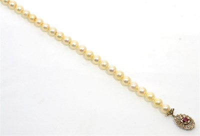 Lot 199 - A cultured pearl necklace with an 18 carat white gold ruby set clasp, a uniform strand of...