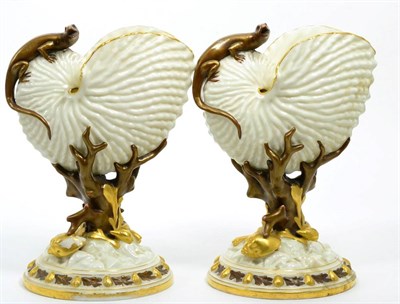 Lot 302 - A pair of Royal Worcester nautilus shell vases, with applied lizards, blush ground and gilt...