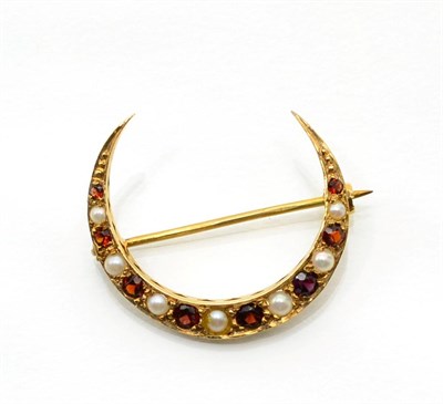 Lot 329 - A 9 carat gold garnet and cultured pearl crescent brooch, graduated oval cut garnets spaced by...