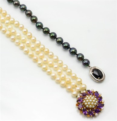 Lot 333 - A black cultured pearl necklace, uniform cultured pearls knotted to an onxy set clasp, stamped...