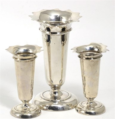 Lot 387 - A set of three silver vases, Deakin & Francis, Birmingham 1911 and 1915, with shaped rim, bases...