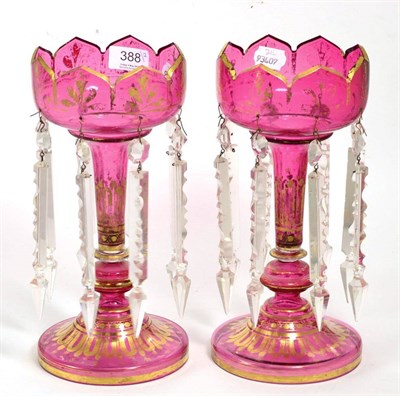 Lot 388 - A pair of Victorian cranberry glass lustres