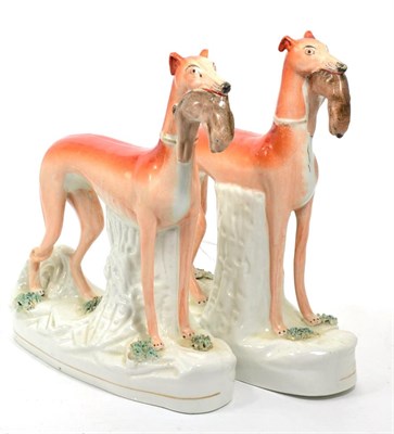 Lot 407 - A pair of 19th century Staffordshire figures of hounds holding hares in their jaws,...