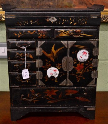 Lot 473 - A late 19th century black lacquered and gilt embellished table cabinet, two inset porcelain panels