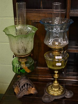 Lot 475 - An oil lamp with spelter base, green glass reservoir and shade, together with another oil lamp