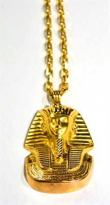 Lot 481 - An Egyptian Tutankhamum pendant, measures 4cm by 3cm, on a cable chain necklace, length 61.5cm,...