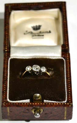 Lot 483 - An 18 carat gold diamond three stone ring, graduated round cut diamonds in rubbed over settings, to