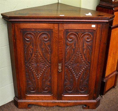 Lot 1261 - A carved oak corner cabinet