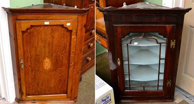 Lot 1263 - A George III oak hanging corner cupboard together with a glazed example (2)