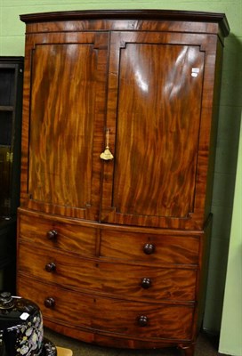 Lot 1349 - A George III mahogany bow fronted linen press with three drawers to base