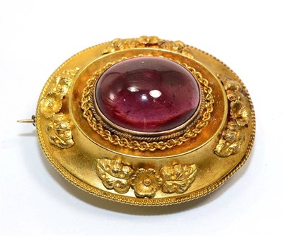 Lot 339 - A Victorian garnet brooch, an oval cabochon garnet in a rubbed over setting, within a domed...