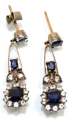 Lot 344 - A pair of blue and white sapphire drop earrings, an oval cut sapphire suspends a knife edge...