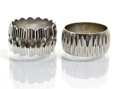 Lot 356 - Two 9 carat white gold broad band rings, with faceted decoration, finger size K and L (2)