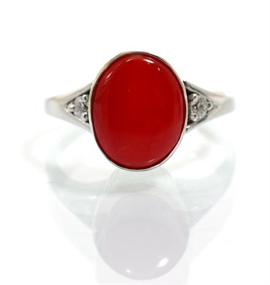 Lot 358 - An 18 carat white gold coral and diamond ring, an oval cabochon coral in a rubbed over setting,...