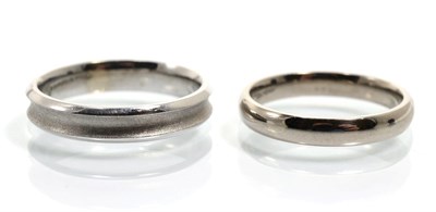 Lot 370 - An 18 carat white gold ridged and brushed polished band ring, finger size O and a plain 18...