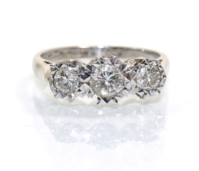 Lot 372 - An 18 carat white gold diamond three stone ring, graduated round brilliant cut diamonds in illusion