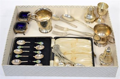 Lot 382 - A mixed group of silver items to include a set of enamel tea spoons; two Christening mugs; peppers