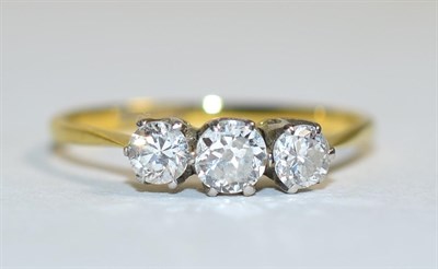 Lot 409 - A diamond three stone ring, graduated old cut diamonds in claw settings, to knife edge...