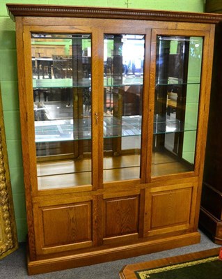 Lot 1187 - A modern oak display cabinet, fitted with two doors