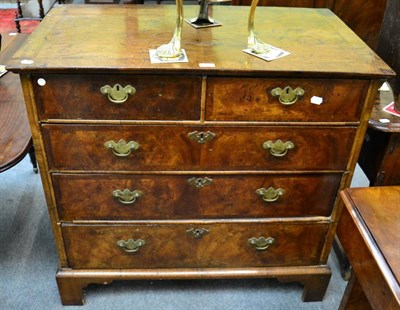 Lot 1211 - A walnut crossbanded four height chest of drawers, on bracket feet