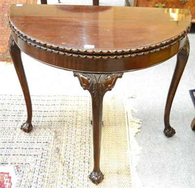 Lot 1221 - A carved mahogany fold over card table