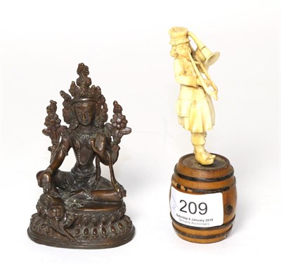 Lot 209 - A bronze Tibetan Buddha figure and a late 19th century ivory trumpeter figure, standing on a barrel