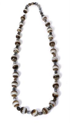 Lot 255 - A banded agate and glass bead necklace, a continuous strand of round banded agate beads alternating