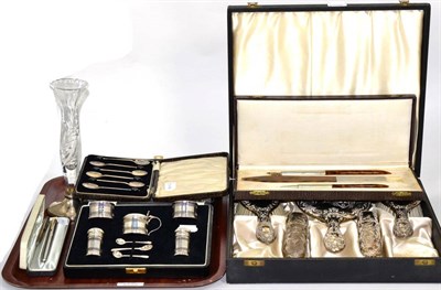 Lot 13 - A silver condiment set, in a fitted case; a silver brush and mirror set decorated with cherubs,...