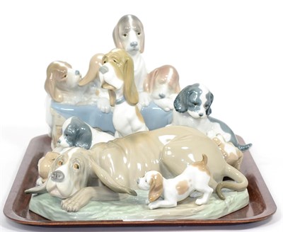 Lot 17 - Lladro figure ";Pups in the Box"; no. 1121, a Nao figure of a Basset hound with pup and three other