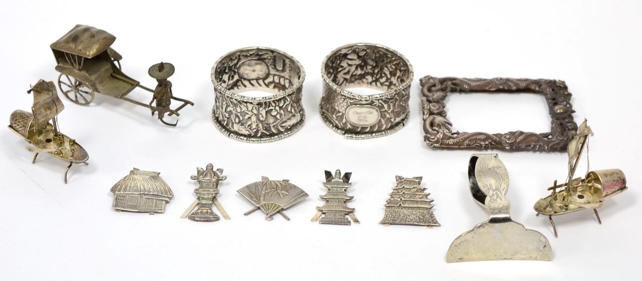 Lot 64 - A set of five Japanese white metal place card holders, stamped Sterling, modelled as a fan, pagodas