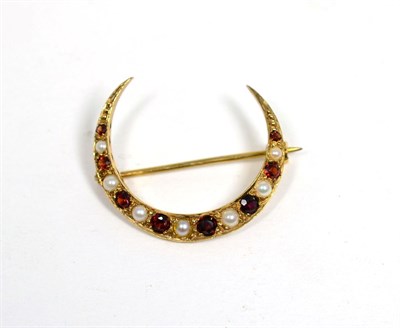 Lot 86 - A 9 carat gold garnet and cultured pearl crescent brooch, graduated oval cut garnets spaced by...