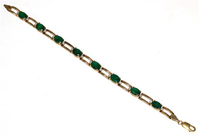 Lot 175 - A 9 carat gold emerald and diamond bracelet, oval cut emeralds in claw settings, spaced by...