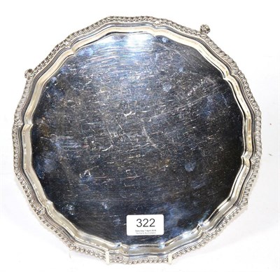 Lot 322 - A circular silver salver, with gadrooned border, on ball and claw feet, 25cm diameter