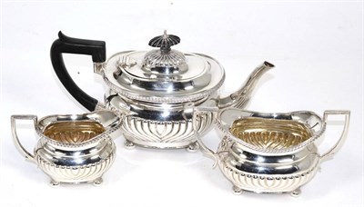 Lot 324 - An Edwardian three piece silver tea service, of oval part fluted design