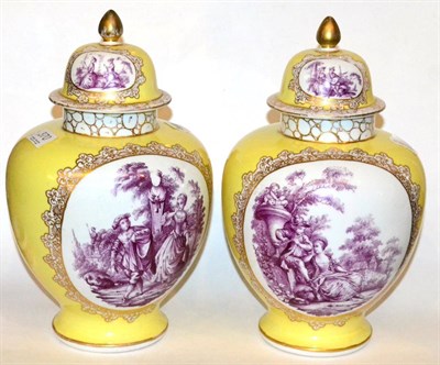 Lot 370 - A pair of continental yellow ground vases and covers, painted with elegant figures in a garden...