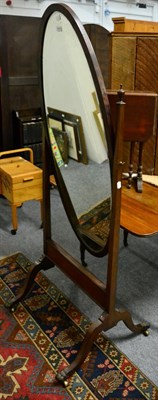 Lot 1069 - An oval mahogany cheval mirror on cabriole supports, with lion paw feet