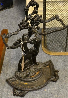 Lot 1115 - A cast iron stick stand modelled as a dog seated beneath a tree