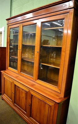 Lot 1207 - A light mahogany glazed bookcase the base with three doors