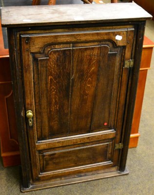 Lot 1209 - A slim oak hanging cupboard with single panelled door