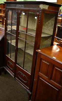 Lot 1227 - An early 20th century mahogany display cabinet with carved bellflower and swag decoration