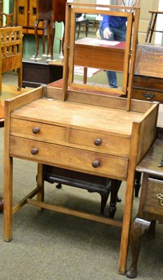 Lot 1240 - An oak dressing table in the Cotswold taste, with rectangular swing mirror and fitted with two...