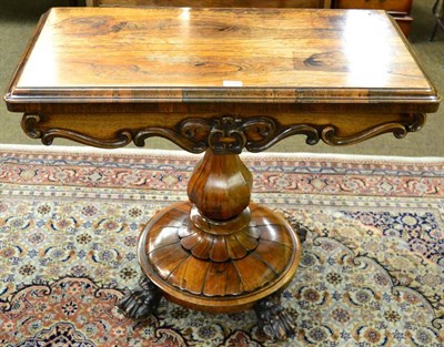 Lot 1244 - An early Victorian rosewood fold over card table, the baluster support on lion paw feet