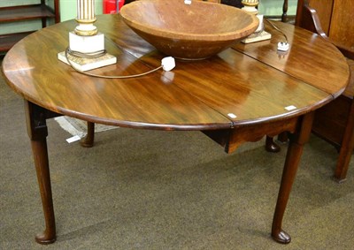 Lot 1245 - A George III mahogany oval drop leaf table on pad feet