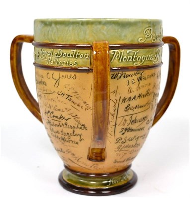Lot 93 - A Royal Doulton Lambeth Stoneware Presentation Loving Cup, with three handles, incised with the...